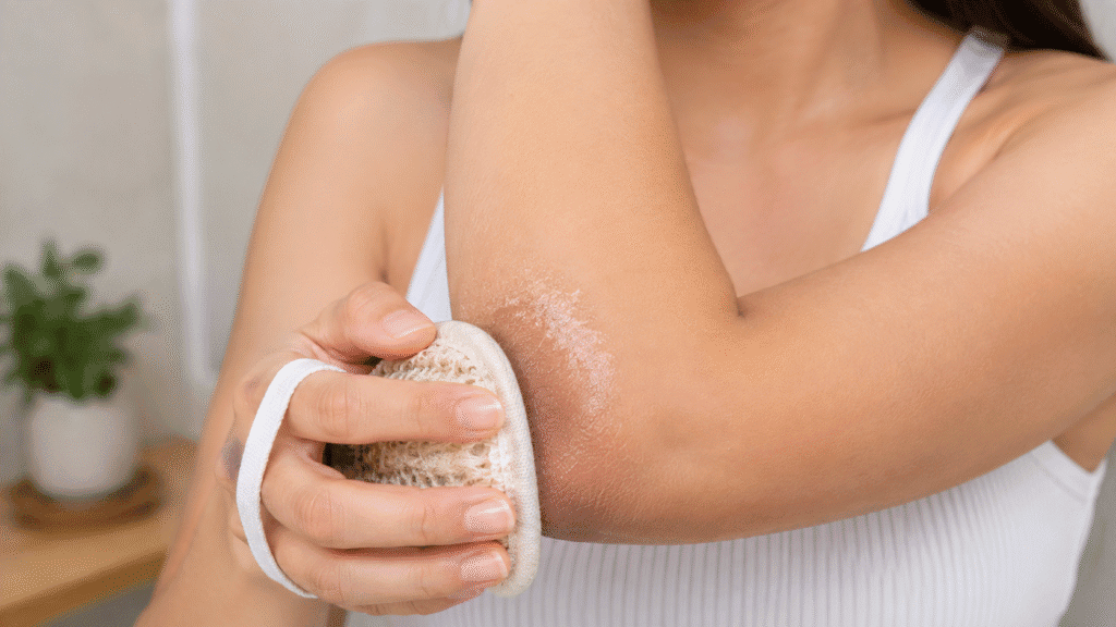 Woman scrubbing her dark, rough-textured elbow.